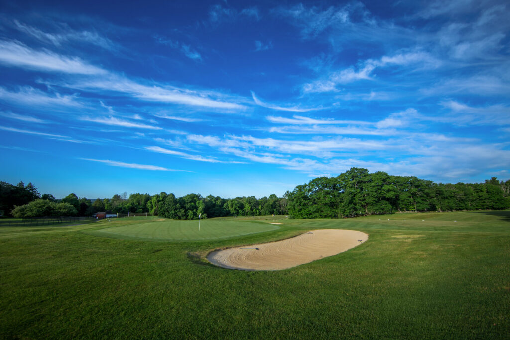 Fairway and green under blue sky at Candia Woods